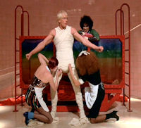 Rocky Horror Picture Show - Rocky emerges from tank Rocky emerges from his rainbow-colored birth tank and is unwrapped from his bandages while Frank looks on in glee.