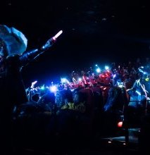 The crowd gets out glow sticks and smartphones during the performance of